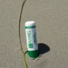 Labial protector con aceite de argán Kamel sobre la arena